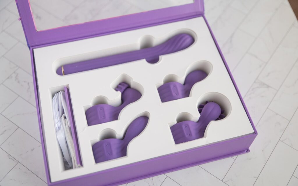All of the attachments and the insertable shaft shown inside of the original packaging. It keeps all of the attachments really organized. For my AVIDLOVE PLAY Four-Attachment Rabbit Vibrator review.
