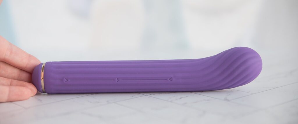 The insertable shaft laid on a flat surface, showcasing the very light, shallow curve of the tip of the toy to hit the g-spot. For my AVIDLOVE PLAY Four-Attachment Rabbit Vibrator review.