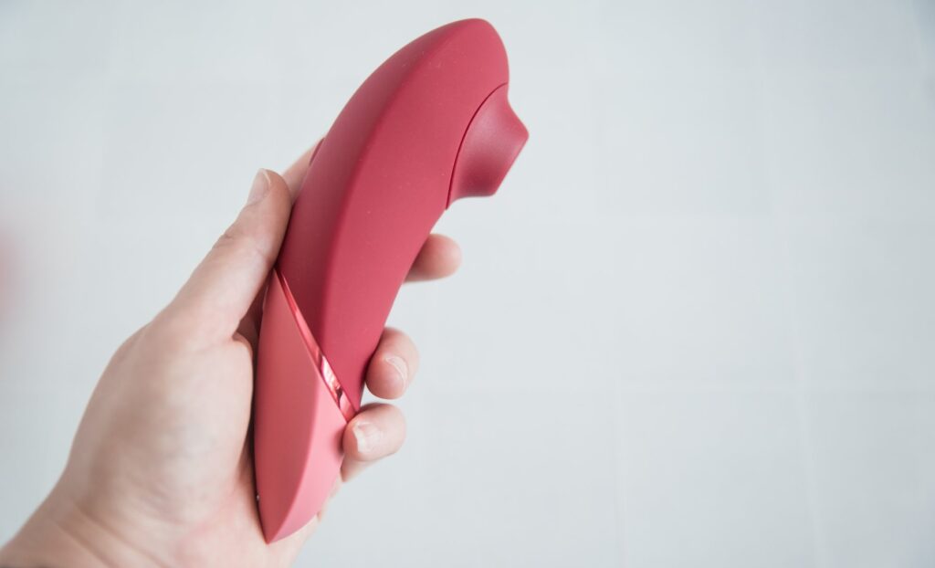 My hand holds the Womanizer Next full-sized. It has a very large, long handle for holding. The tip of the air suction toy has a clear protrusion away from the rest of the "handle". For my Womanizer Next Liberty vs Womanizer Next comparison