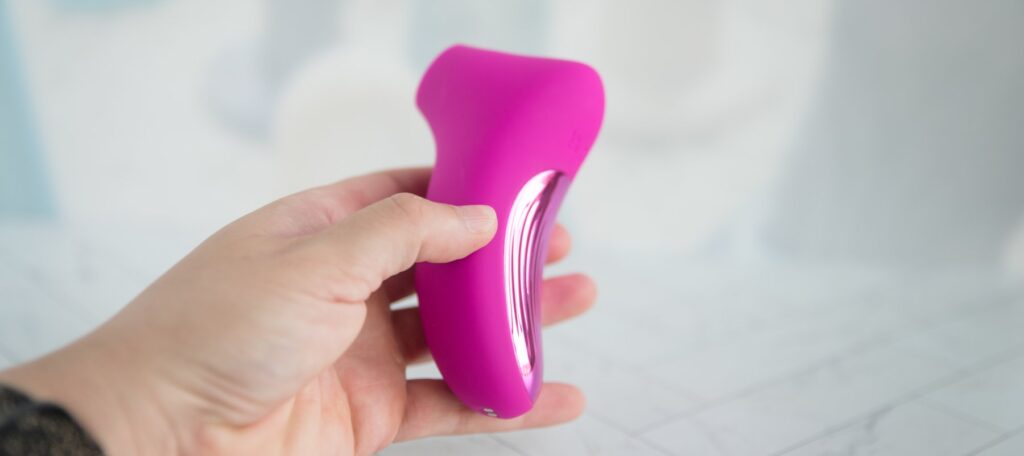 I show the backside of the air suction toy. It has a shiny, colored panel on the backside, making the toy look expensive. For my AVIDLOVE PLAY Ergonomic Max Suction Clitoral Vibrator review.
