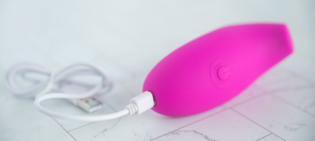 The air suction toy plugged into its magnetic charging cable.