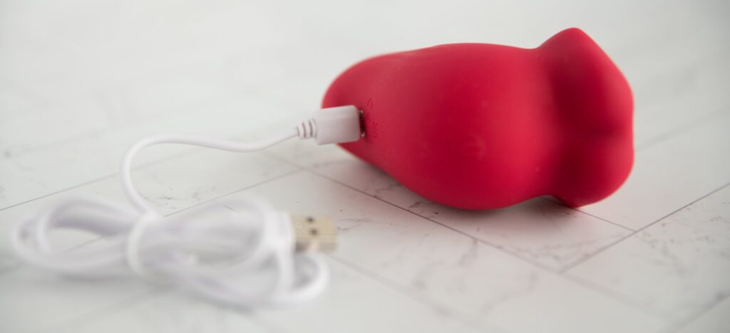 The magnetic charging cord is shown magnetized to the charging port area of the toy. The other end of the charging cable is a USB.