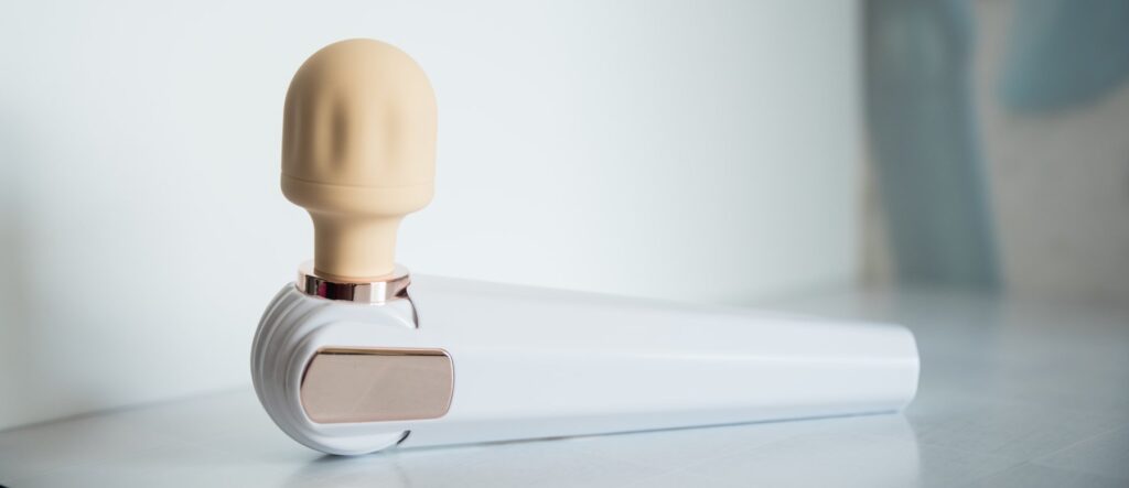 The head of the wand massager is turned at a 90 degree angle. This opposing side of the wand has no buttons or markings on it.