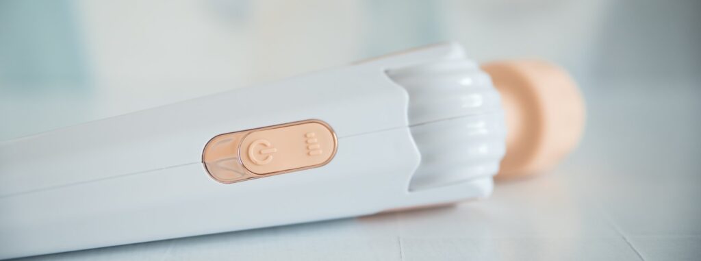 Close-up on the two buttons on the handle of the wand massager. There's an intensity button and a power button. For my GITM PLAYBOOK Bowing-Bowing Review.