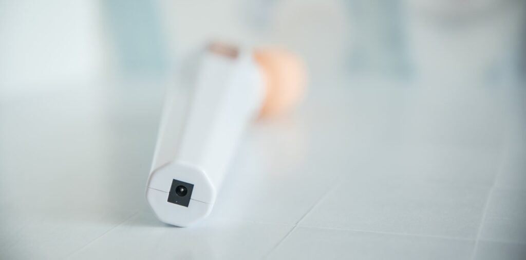 Close-up of the open charging port that charges the vibrator when it's not in use. There's no covering for it at all. It's a completely open hole.