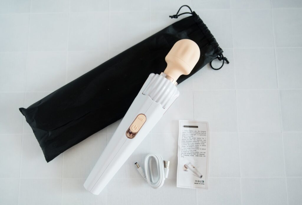 Everything included with the wand massager. There's the wand massager itself, a drawstring bag, the charging cable, and a very small sheet with instructions.