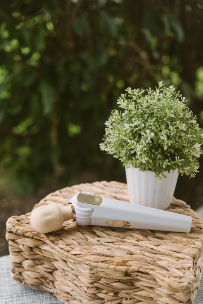 The Bowing-Bowing wand sits out on a woven basket next to a potted plant. There's a bushy green tree in the background. For my GITM PLAYBOOK Bowing-Bowing Review.