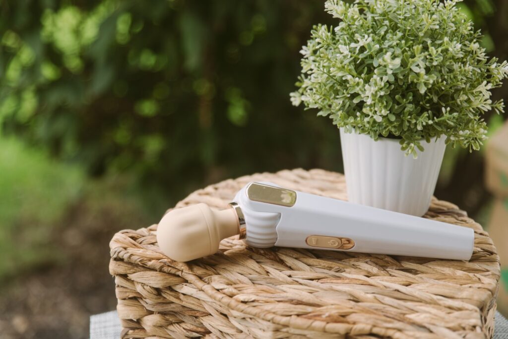 The Bowing-Bowing wand sits out on a woven basket next to a potted plant. There's a bushy green tree in the background. For my GITM PLAYBOOK Bowing-Bowing Review.