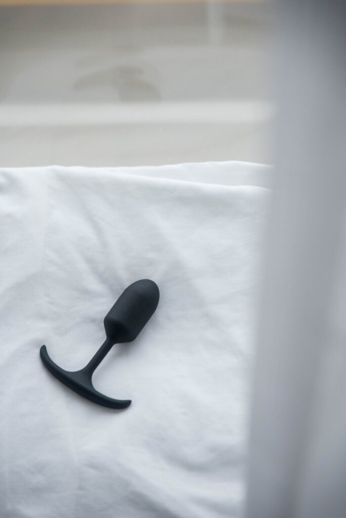 The Booty Buddy plug lies out on top of a plain white pillow near a reflective window. It looks bright, airy, and inviting. For my MEO.de Booty Buddy review.