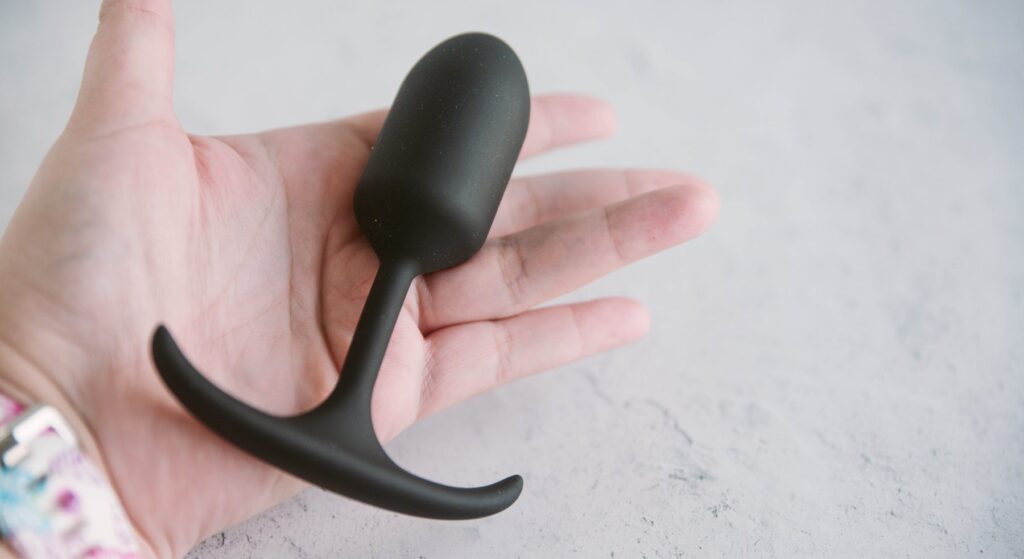 My hand is open with the Booty Buddy resting in the middle of it. This showcases the smaller size of the plug in relation to its wide base.